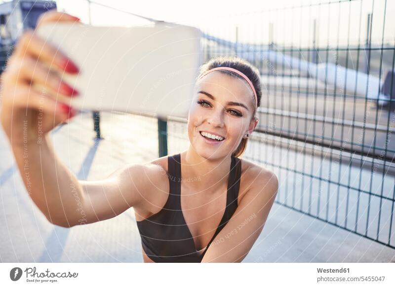 Fitte Frau macht Selfie nach Outdoor-Workout weiblich Frauen Handy Mobiltelefon Handies Handys Mobiltelefone Urban städtisch Urbanität Urbanitaet Smartphone