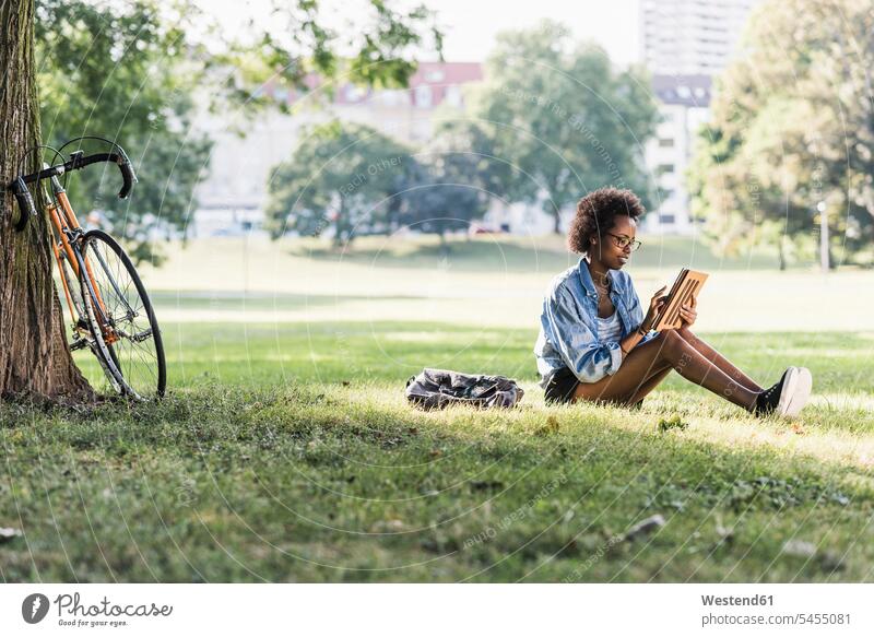 Junge Frau ruht sich mit Tablette im Park aus Tablet Computer Tablet-PC Tablet PC iPad Tablet-Computer weiblich Frauen Parkanlagen Parks sitzen sitzend sitzt