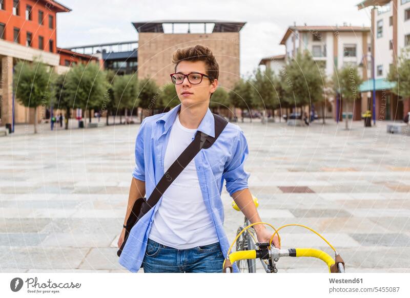 Porträt eines jungen Mannes, der sein Fahrrad schiebt Portrait Porträts Portraits Männer männlich Erwachsener erwachsen Mensch Menschen Leute People Personen