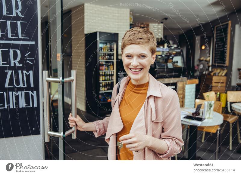 Weibliche Cafebesitzerin schließt morgens die Tür auf lächeln Frau weiblich Frauen Kaffeehaus Bistro Cafes Café Cafés Kaffeehäuser Erwachsener erwachsen Mensch
