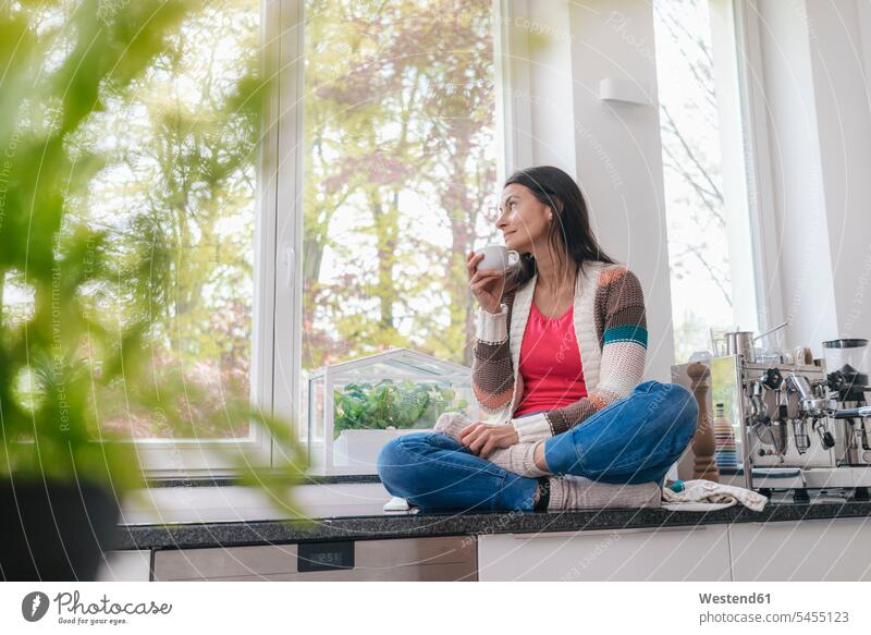 Frau in der Küche, die aus dem Fenster schaut weiblich Frauen sitzen sitzend sitzt Kaffee entspannt entspanntheit relaxt Erwachsener erwachsen Mensch Menschen