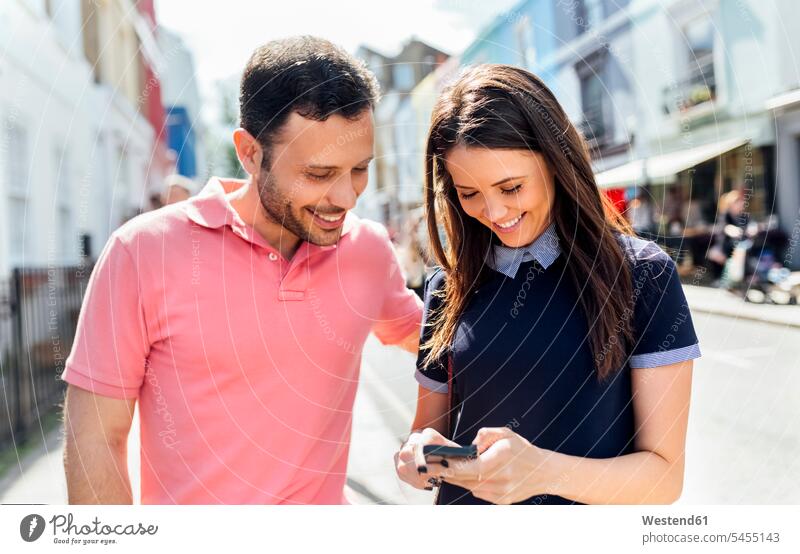 Großbritannien, London, Portobello Road, Ehepaar beim Blick aufs Handy Smartphone iPhone Smartphones Paar Pärchen Paare Partnerschaft Mobiltelefon Handies