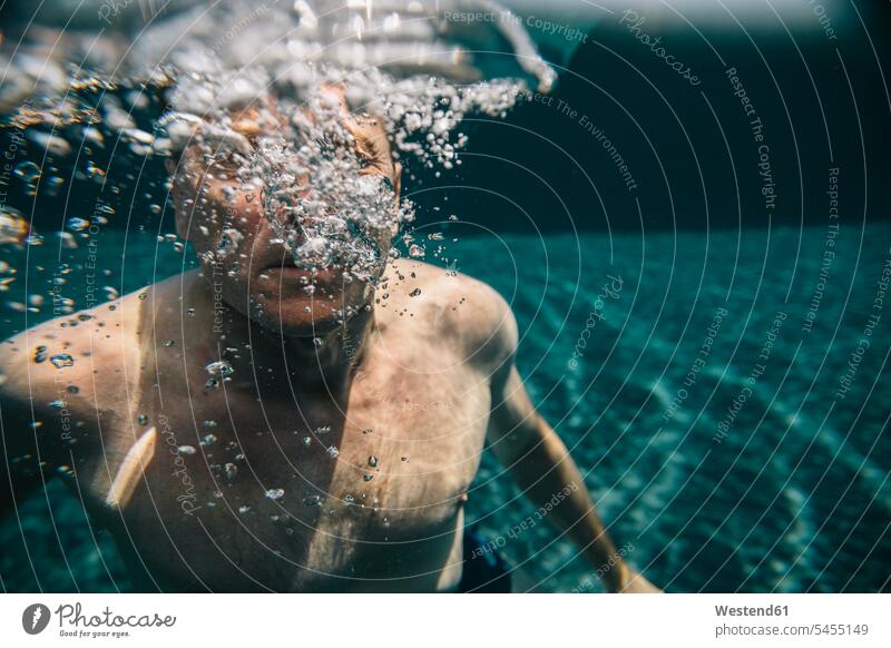 Mann macht Luftblasen unter Wasser in einem Schwimmbad Unterwasser Unterwasseraufnahme Unterwasserfoto Blase Bläschen Blasen Blaeschen Swimmingpool