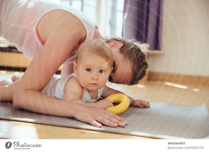 Mutter küsst ihr Baby beim Training auf einer Yogamatte trainieren Babies Babys Säuglinge Kind Kinder Yoga-Übungen Yogauebungen Yogaübungen Jogauebung