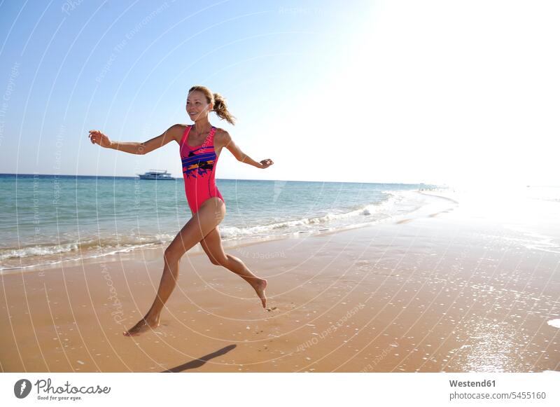 Ägypten, Soma Bay, glückliche Frau rennt am Strand weiblich Frauen Beach Straende Strände Beaches laufen rennen Erwachsener erwachsen Mensch Menschen Leute
