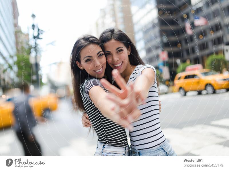 USA, New York City, Porträt von zwei schönen Zwillingsschwestern in Manhattan, die sich amüsieren Spaß Spass Späße spassig Spässe spaßig Schwester Schwestern