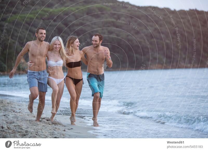 Vier glückliche Freunde am Strand Spaß Spass Späße spassig Spässe spaßig Glück glücklich sein glücklichsein lachen Freundschaft Kameradschaft positiv Emotion