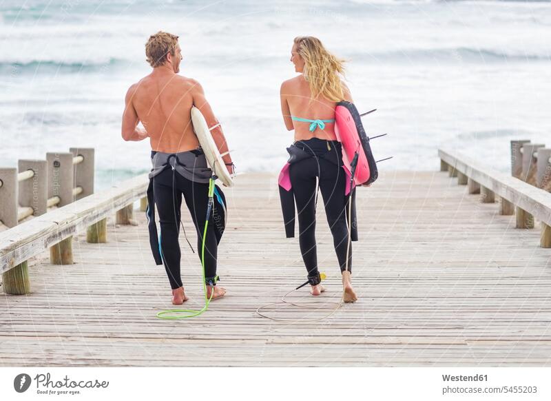 Paare, die mit Surfbrettern zum Strand gehen Beach Straende Strände Beaches Surfen Surfing Wellenreiten tragen transportieren gehend geht surfboard surfboards
