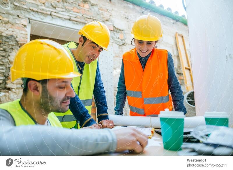Lächelnde Frau und zwei Bauarbeiter auf der Baustelle Baustellen Kollegen Arbeitskollegen lächeln Handwerker Handwerksberuf Handwerksberufe Gewerbe Konstruktion