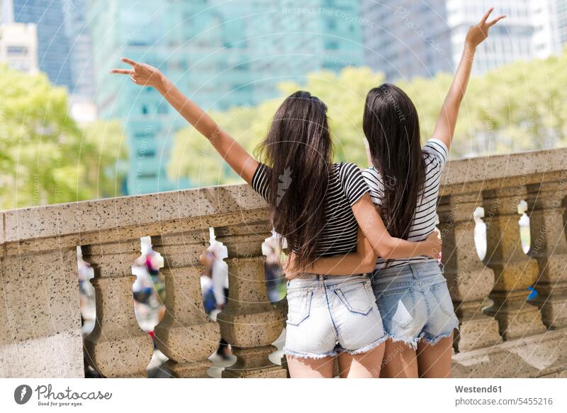 USA, New York City, Rückansicht von zwei jungen Frauen in Manhattan, die sich amüsieren Spaß Spass Späße spassig Spässe spaßig Schwester Schwestern Freundinnen
