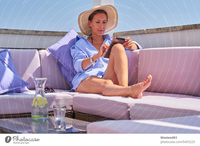 Frau mit Tablette entspannt auf dem Sonnendeck Glas Trinkgläser Gläser Trinkglas Urlaub Ferien Tablet Computer Tablet-PC Tablet PC iPad Tablet-Computer Wasser