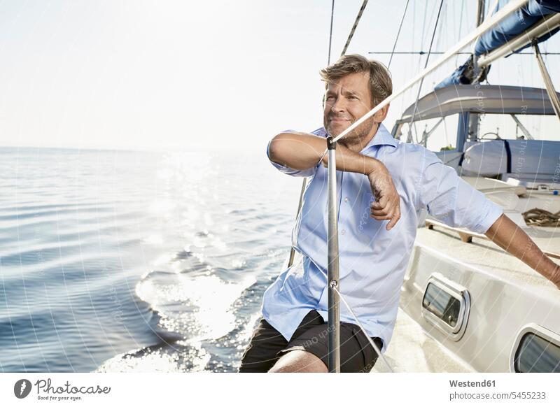 Porträt eines lächelnden reifen Mannes auf seinem Segelboot Segeln segelnd segelt Männer männlich Bootsport Erwachsener erwachsen Mensch Menschen Leute People