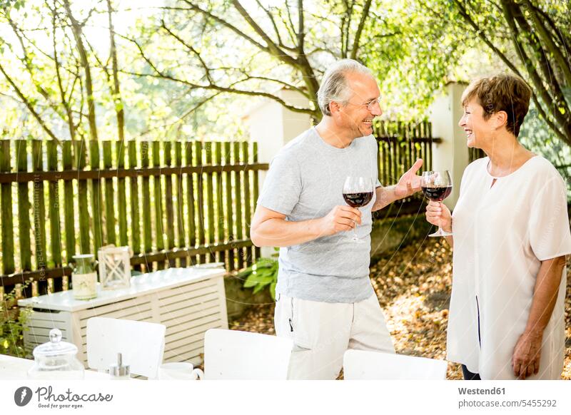 Glückliches älteres Ehepaar bei einem Glas Rotwein im Freien Wein Weine lächeln Paar Pärchen Paare Partnerschaft Alkohol Alkoholische Getraenke