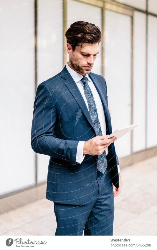 Gutaussehender Geschäftsmann mit digitalem Tablet attraktiv schoen gut aussehend schön Attraktivität gutaussehend hübsch lesen Lektüre Tablet Computer Tablet-PC