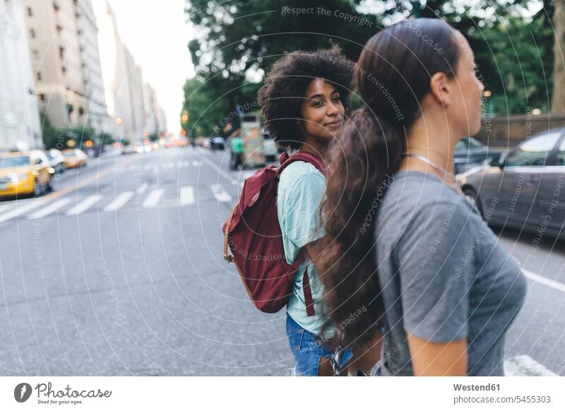 USA, New York City, zwei Freunde überqueren die Straße Freundinnen Strassen Straßen Freundschaft Kameradschaft gehen gehend geht Frau weiblich Frauen lächeln