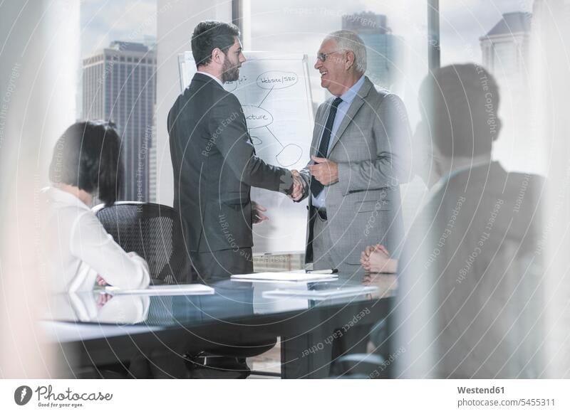 Zwei Geschäftsleute schütteln sich bei Bürobesprechung die Hand Präsentation Praesentationen Präsentationen Geschäftsmann Businessmann Businessmänner