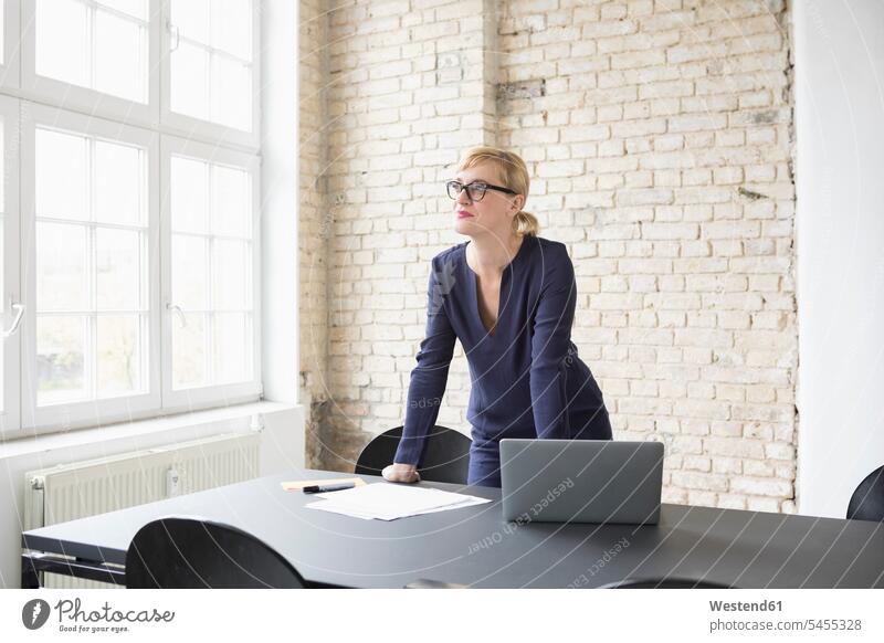 Erfolgreiche Geschäftsfrau steht in ihrem Büro arbeiten Arbeit Laptop Notebook Laptops Notebooks Geschäftsfrauen Businesswomen Businessfrauen Businesswoman