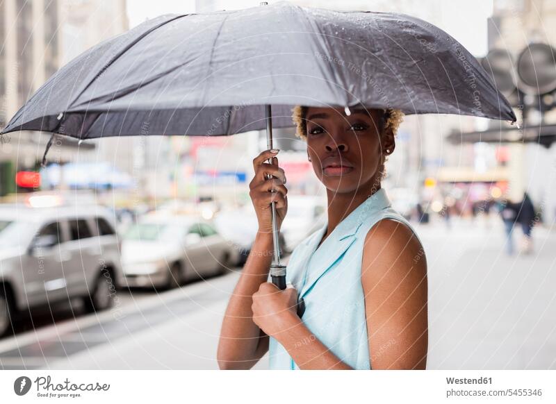 USA, New York, Porträt einer jungen blonden afro-amerikanischen Frau mit Regenschirm Afroamerikanisch Afro-Amerikanisch Afroamerikaner Afro-Amerikaner regnen