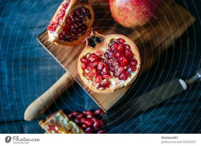 Granatapfel in Scheiben und ganzer Granatapfel auf Schneidebrett Niemand rot rote roter rotes Messer Frische frisch Gesunde Ernährung Ernaehrung