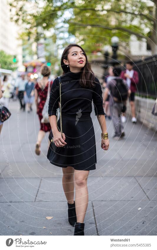 USA, New York City, Manhattan, modische, schwarz gekleidete junge Frau geht auf dem Bürgersteig weiblich Frauen Erwachsener erwachsen Mensch Menschen Leute