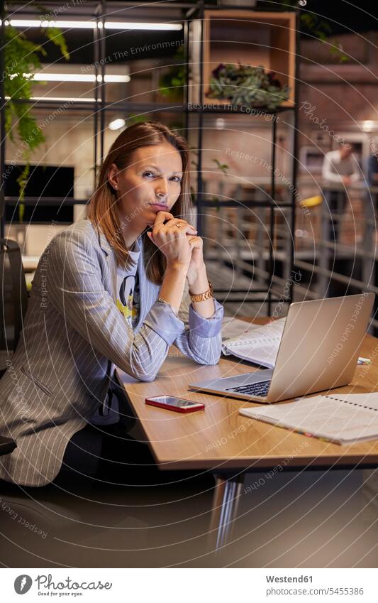 Geschäftsfrau, die in einem modernen Büro arbeitet und einen Laptop benutzt sitzen sitzend sitzt arbeiten Arbeit Schreibtisch Arbeitstisch Schreibtische Office