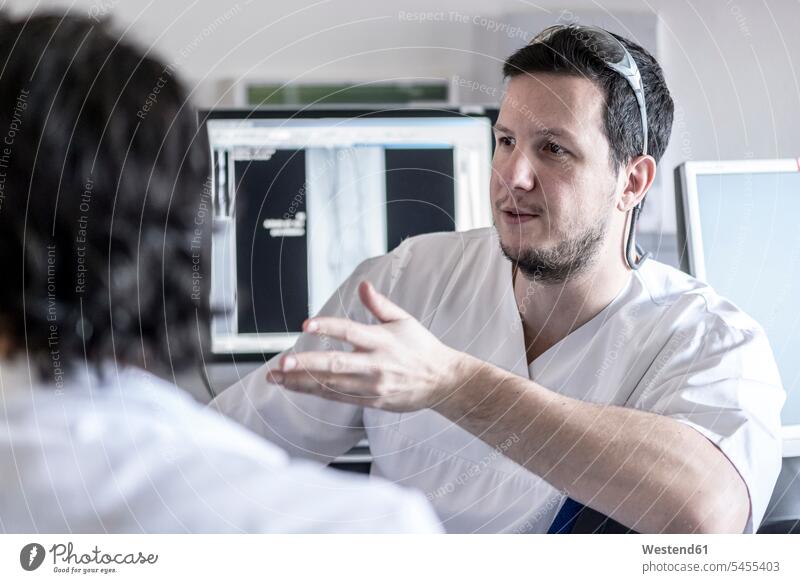 Zwei Ärzte im Gespräch Röntgenbild Roentgenbild Roentgenbilder Röntgenaufnahmen Roentgenaufnahmen Röntgenbilder besprechen diskutieren Besprechung Arzt Doktoren