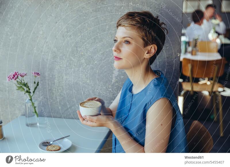 Seriöse Frau mit einer Tasse Kaffee in einem Café weiblich Frauen Cafe Kaffeehaus Bistro Cafes Cafés Kaffeehäuser ernst Ernst Ernsthaftigkeit ernsthaft