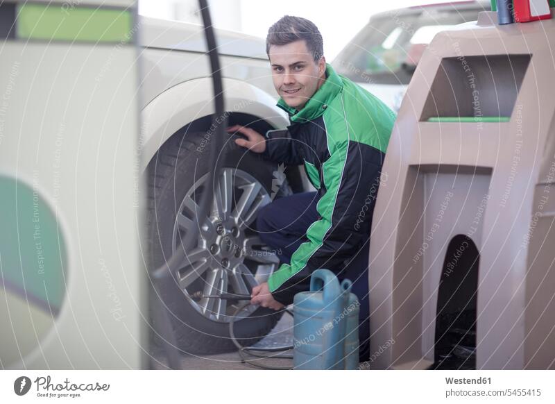 Mann füllt Autoreifen an der Tankstelle mit Luft Tankwart Wagen PKWs Automobil Autos füllen abfüllen Füllung Kraftfahrzeug Verkehrsmittel KFZ Verkehrswesen