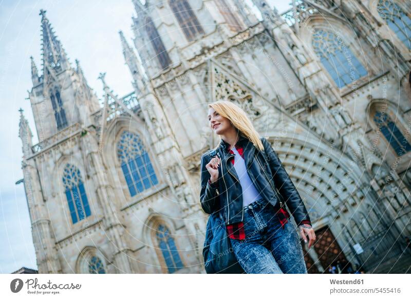 Spanien, Barcelona, lächelnde junge Frau geht vor der Kathedrale weiblich Frauen Erwachsener erwachsen Mensch Menschen Leute People Personen Touristin