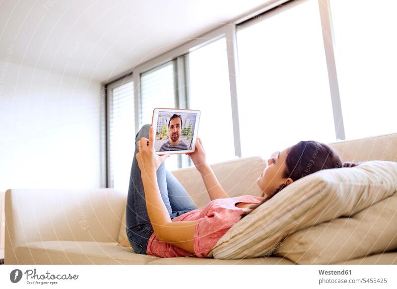 Junge Frau benutzt Tablet für Video-Chat zu Hause Video Chat Fernbeziehung Tablet Computer Tablet-PC Tablet PC iPad Tablet-Computer weiblich Frauen chatten
