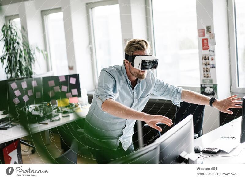 Geschäftsmann mit VR-Brille im Büro Brillen Virtuelle Realität Virtuelle Realitaet Office Büros Businessmann Businessmänner Geschäftsmänner Arbeitsplatz