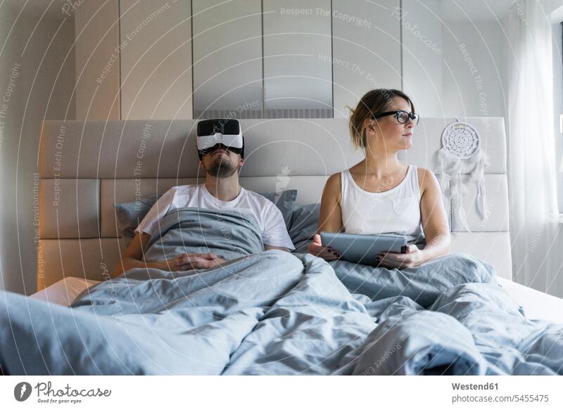 Paar im Bett zu Hause mit Tablette und VR-Brille Brillen Virtuelle Realität Virtuelle Realitaet Tablet Computer Tablet-PC Tablet PC iPad Tablet-Computer Zuhause