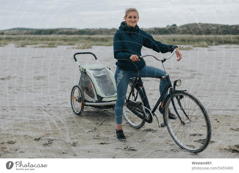 Niederlande, Schiermonnikoog, Frau mit Fahrrad und Anhänger am Strand Bikes Fahrräder Räder Rad weiblich Frauen Beach Straende Strände Beaches Raeder