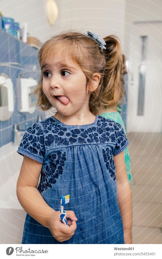 Porträt eines Mädchens mit Zahnbürste im Badezimmer eines Kindergartens Kindergaerten Kindergärten Zahnbürsten Zähne putzen Zaehne putzen weiblich Pädagogik
