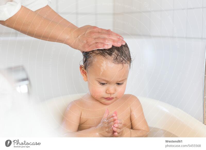 Mutter badet ihr kleines Mädchen in einer Badewanne Badewannen weibliche Babys weibliches Baby weibliche Babies Kind Kinder Mensch Menschen Leute People