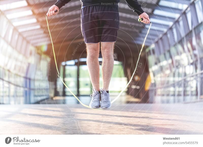 Junger Mann beim Seilspringen auf einer Brücke Bruecken Brücken Sportler aktiv hüpfen trainieren Seile seilspringen hüpft Seil seilspringend Seil springen