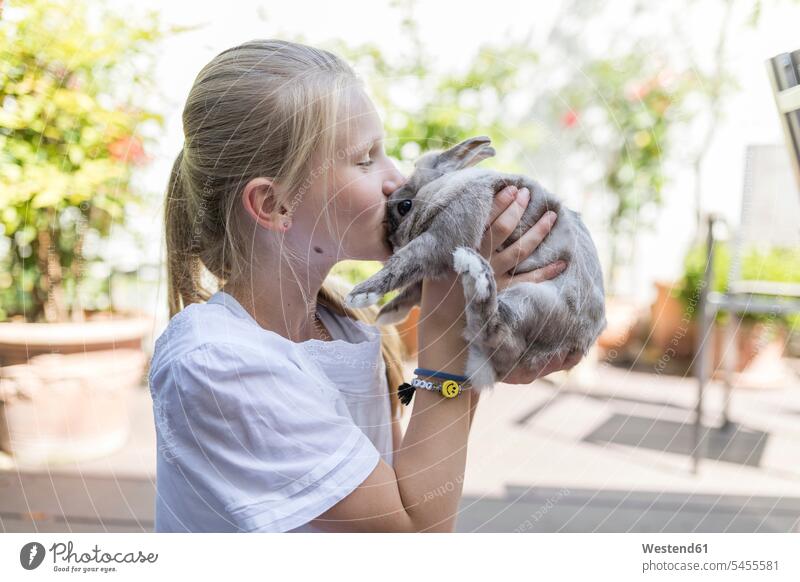 Mädchen küsst Kaninchen im Freien weiblich kuscheln schmusen knuddeln Karnickel küssen Küsse Kuss Kind Kinder Kids Mensch Menschen Leute People Personen Hase