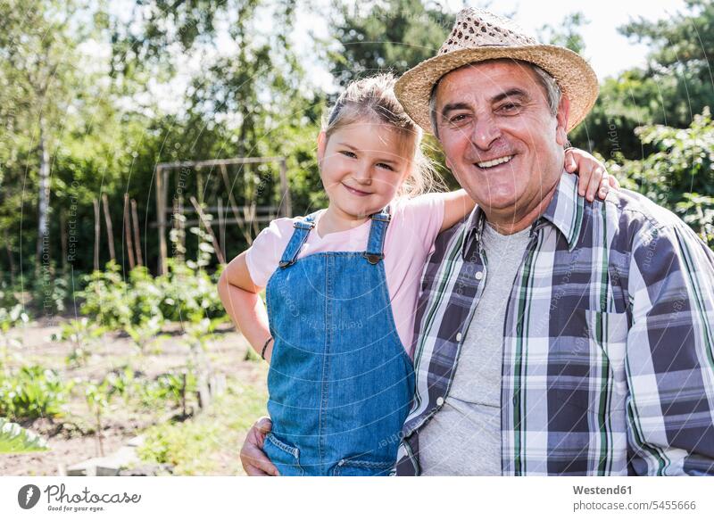 Porträt von lächelndem Großvater und Enkelin im Garten Opa Großpapa Großpapas Opas Opi Großväter Opis Gärten Gaerten Enkeltochter Enkelinnen Enkeltöchter