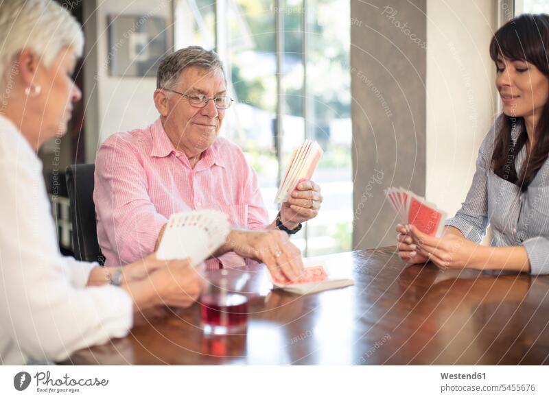 Älteres Ehepaar spielt mit der Tochter zu Hause Karten spielen Töchter Zuhause daheim Senior ältere Männer älterer Mann Senioren Paar Pärchen Paare