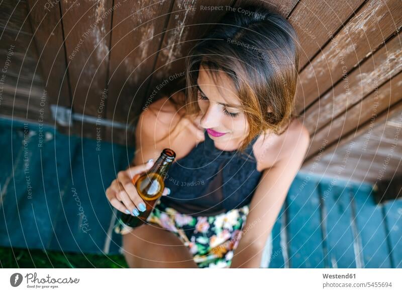 Junge Frau mit Bier in Holzhütte sitzend entspannt entspanntheit relaxt weiblich Frauen sitzt trinken Entspannung relaxen entspannen Erwachsener erwachsen