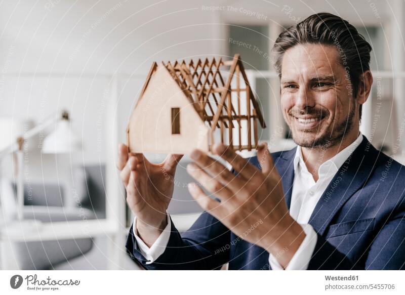 Lächelnder Architekt untersucht Architekturmodell Modell Modelle lächeln Mann Männer männlich ansehen Architekten Erwachsener erwachsen Mensch Menschen Leute