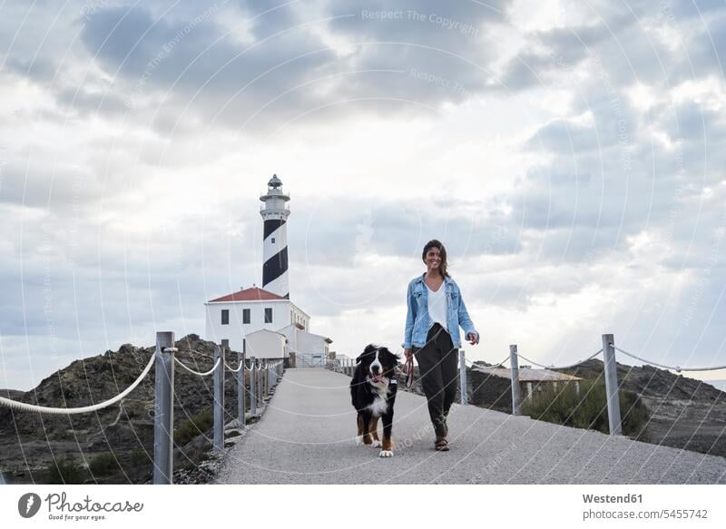 Spanien, Menorca, Berner Sennenhund beim Spaziergang mit seinem Besitzer im Freien am Leuchtturm Hund Hunde Berner Sennenhunde Leuchttürme gehen gehend geht