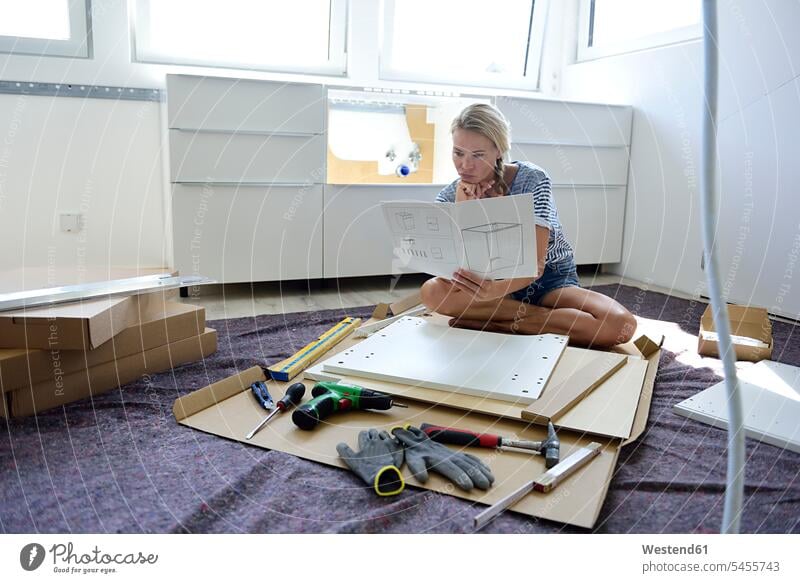 Frau liest Montageanleitung zu Hause Heimwerken Do-it-Yourself DIY weiblich Frauen aufbauen lesen Lektüre Erwachsener erwachsen Mensch Menschen Leute People