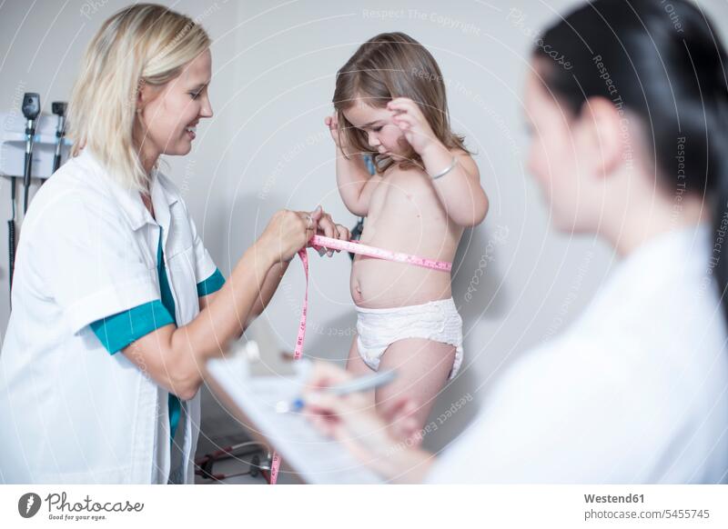 Arzt misst einen kleinen Patienten Maßband Messband Metermaß Massband messen abmessen Kinderarzt Kinderärzte Kinderaerzte Mädchen weiblich Doktoren Ärzte