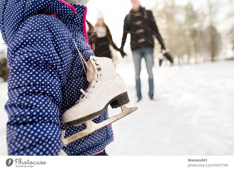 Kleines Mädchen geht mit ihren Eltern Schlittschuh laufen Schlittschuhlaufen Eislaufen Winter winterlich Winterzeit weiblich eislaufen schlittschuhlaufen