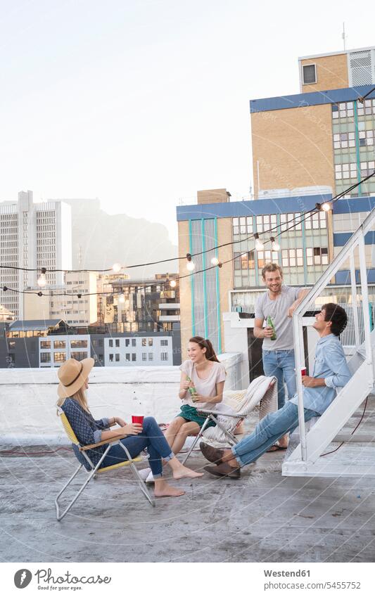 Freunde feiern an einem schönen Sommerabend eine Party auf dem Dach genießen geniessen Genuss trinken Gemeinsam Zusammen Miteinander Dachterrasse Dachterrassen