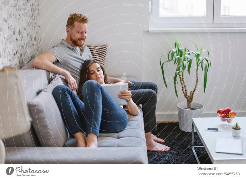 Ehepaar auf dem Sofa im Wohnzimmer mit Tablett Paar Pärchen Paare Partnerschaft Tablet Computer Tablet-PC Tablet PC iPad Tablet-Computer Mensch Menschen Leute