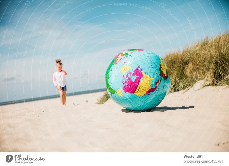 Globus am Strand mit Mädchen im Hintergrund weiblich Beach Straende Strände Beaches Weltkugel Erdkugel Globen Kind Kinder Kids Mensch Menschen Leute People