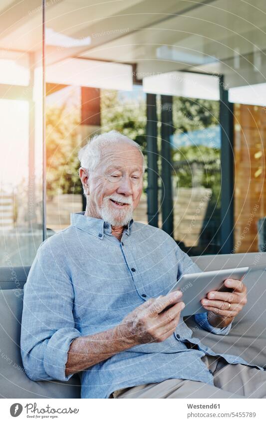Älterer Mann sitzt auf der Terrasse und liest eBook lesen Lektüre Terrassen E-Book Senior ältere Männer älterer Mann Senioren Rentner Pensionär Pensionäre