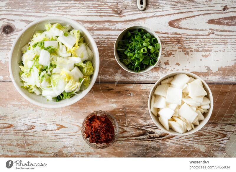 Zutaten für koreanische Kimchi, Chinakohl, Radieschen, Frühlingszwiebeln und Paprika Asiatische Küche Asiatisches Essen Paprikapulver Holz hoelzern hölzern